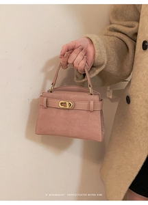 Detail of dusty pink frosted suede handbag with vintage gold buckle and slim handle