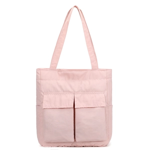 Close-up of pink nylon tote bag featuring dual front pockets and durable shoulder straps
