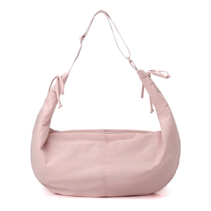 Detail of light pink nylon crescent bag featuring adjustable shoulder strap and bow tie