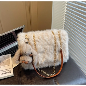 Dettaglio borsa shopper in peluche con catena dorata e ciondolo a forma di coniglio