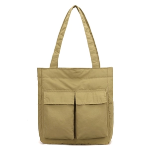 Detail of khaki tote bag featuring large utility flap pockets and durable nylon fabric