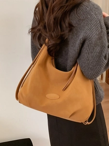 Minimalistische braune Leder-Einkaufstasche in der Rückansicht am Modell mit Kordelträgern
