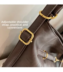 Macro shot of dark brown leather shoulder strap with adjustable golden metal buckle