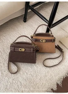 Close-up of retro matte suede crossbody bags with white contrast stitching and gold buckle