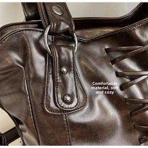 Detail of vintage tote bag with metal rings, rivets, and side lacing on soft brown PU