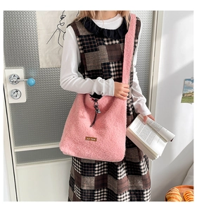 Detail of pink faux shearling tote bag featuring a brown leather 'our fave' logo patch