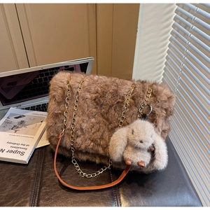 Dettaglio borsa tote in peluche marrone con ciondolo a coniglio e tracolla a catena dorata