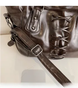 Detail of adjustable shoulder strap with silver buckle on vintage brown leather tote bag