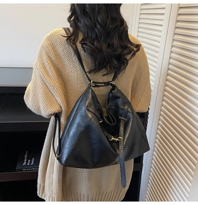 Detail of black large-capacity crossbody backpack with adjustable strap and metal hardware