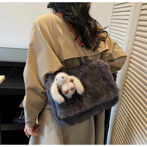 Dettaglio borsa tote in ecopelliccia grigio scuro con ciondolo a coniglio e tracolla