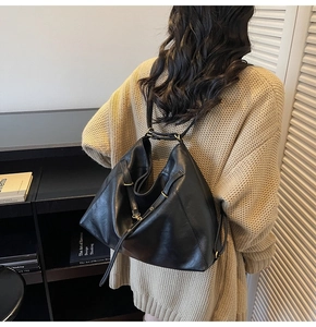 Detail of glossy black soft leather hobo bag with adjustable gold buckle and thin shoulder strap