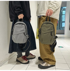 Detail view of water-resistant plaid nylon chest bags in gray and olive green colors