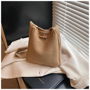 Détail du sac seau tricoté beige avec fermoir bascule en bois et étiquette MISS blanche