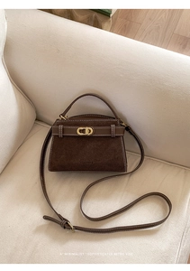 Detail of dark brown retro crossbody bag featuring matte suede and contrast white stitching