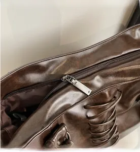 Detail of the smooth gunmetal zipper closure on a brown vintage leather tote bag