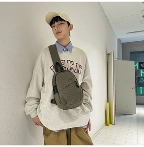 Detail view of the green checkered crossbody chest bag shown on a male model for scale
