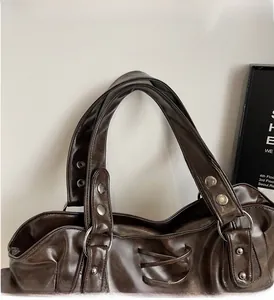 Detail of vintage brown leather tote handle with silver rivets and lacing elements