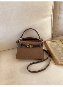 Detailed view of vintage matte leather handbag with contrast stitching and golden buckle