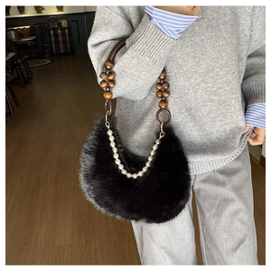Détail d'un sac demi-lune noir en fausse fourrure avec anse en perles de bois