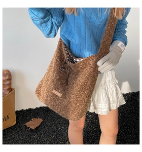 Detail of plush brown tote bag with leather drawstring and textured curly fleece surface