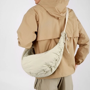 Detailed close-up of large off-white nylon crescent bag with stylish pleated texture