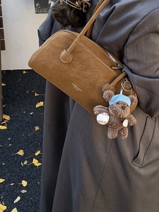 Sac Boston vintage en daim caramel avec pendentif ours, style urbain automnal élégant