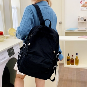 Detailansicht des schwarzen Nylon-Rucksacks mit Reißverschluss und verstellbaren Schnallen