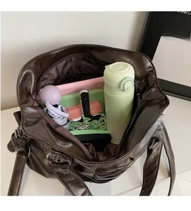 Interior view showing large capacity for water bottle, umbrella and notebook in brown tote bag