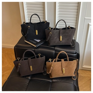 Close-up of trapezoidal tote bags in four colors with elegant golden metal locks and straps