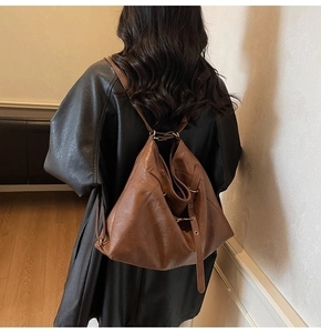 Rear view of model wearing a brown soft faux leather versatile large capacity backpack