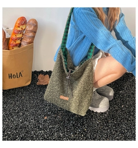 Detail of dark green fuzzy tote bag with mohair texture and stylish gingham inner lining