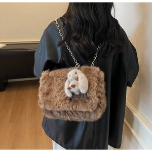 Dettaglio borsa shopper in peluche marrone con catena dorata e ciondolo a coniglio
