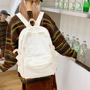 Detail des weißen Rucksacks mit großem Fassungsvermögen, Doherty-Logo und rosa Schnallen