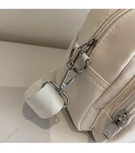 Detail of high-gloss silver hardware and cream woven fabric on woman square bag