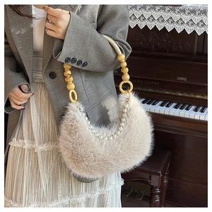 Détail du sac en fausse fourrure crème avec poignée en perles de bois et chaîne perlée