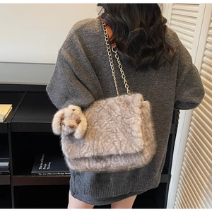 Dettaglio borsa shopper grigia in peluche con ciondolo a coniglio e catena dorata