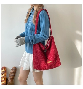 Detail of red plush tote bag showing the soft teddy fleece texture and checkered lining