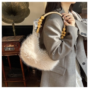 Détail d'un sac en fausse fourrure douce avec anse en perles de bois et chaîne