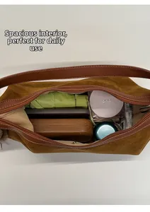 Spacious interior of brown suede crescent bag showing umbrella and cosmetics storage