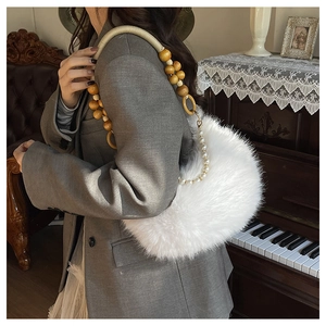 Détail du sac à bandoulière en fausse fourrure blanche avec poignée à perles décorative