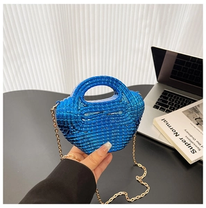 Dettaglio borsa in acrilico blu elettrico con trama a griglia e catena dorata