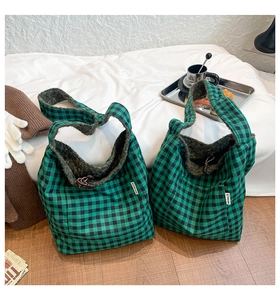Detail of green and black checkered tote bag with warm sherpa fleece lining and front pocket