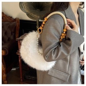 Détail du sac lune en fausse fourrure blanche avec poignée en perles de bois