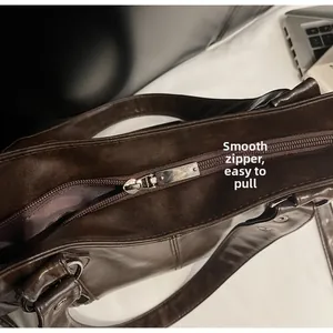 Détail de la fermeture éclair argentée sur le sac cabas en cuir mat marron
