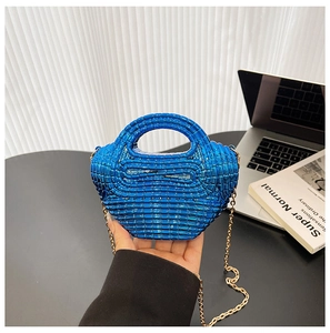 Dettaglio della borsa blu con perline in resina e tracolla a catena dorata lucida