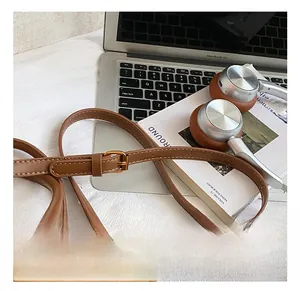 Detail of adjustable leather strap with gold buckle on a brown vintage pillow bag