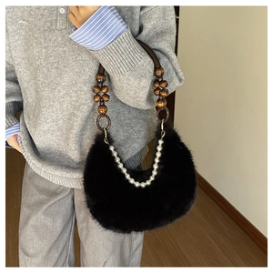 Détail du sac en fausse fourrure noire avec poignée en bois et chaîne de perles