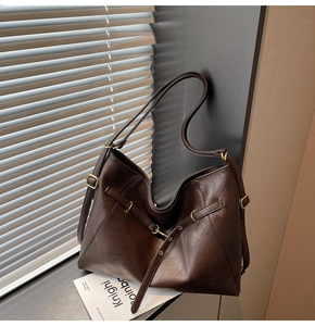 Close-up of vintage brown leather tote bag with gold hardware and soft matte texture