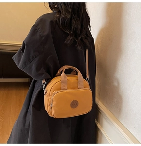 Detail of ginger yellow square shoulder bag with waterproof fabric and bicycle logo