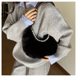 Détail du sac hobo en fausse fourrure noire avec chaîne en perles et anse marron
